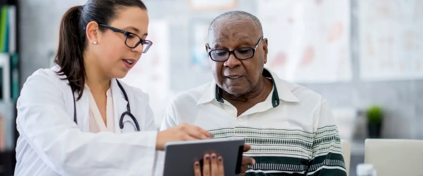 A healthcare professional showing results on a digital tablet to a patient