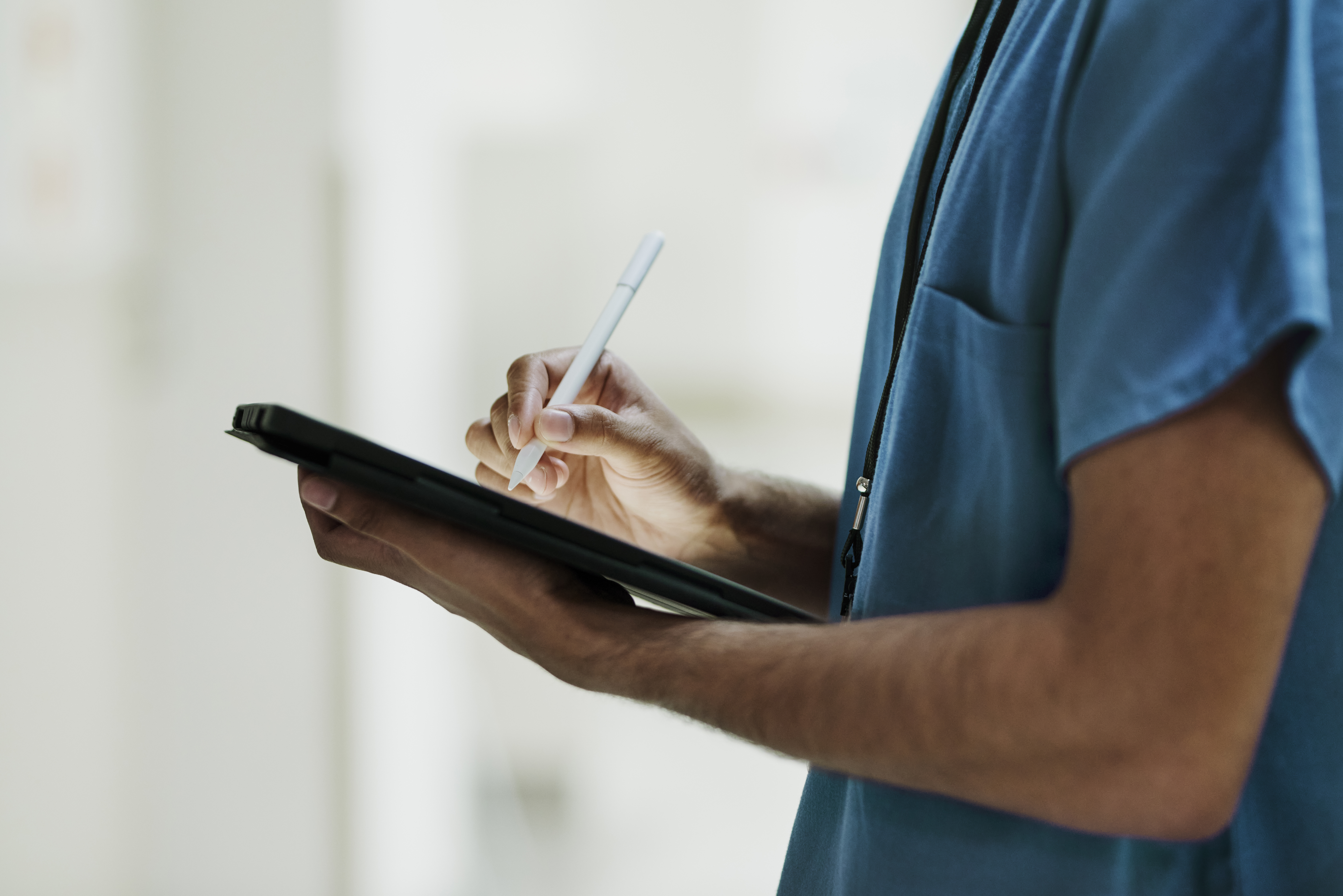 Man in scrubs with tablet